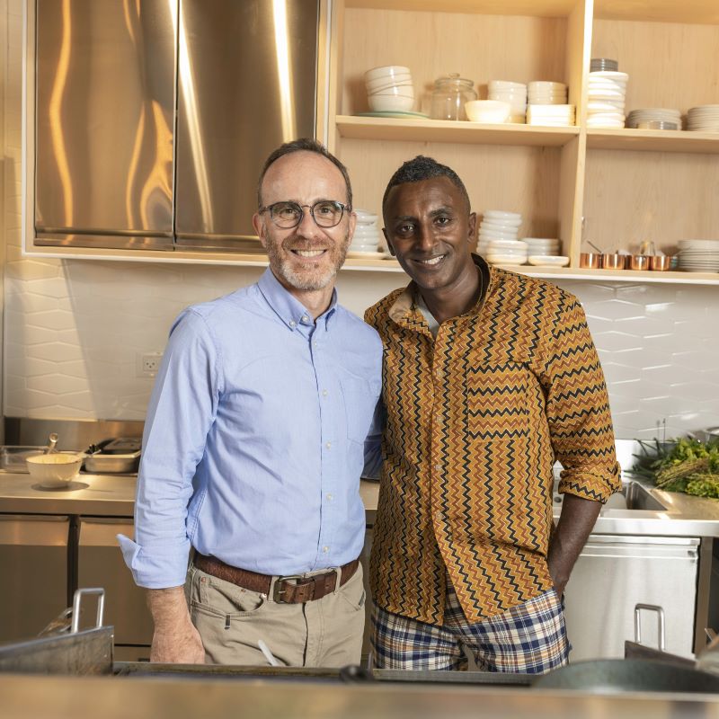 Two businessmen in a kitchen.